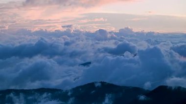 Hehuanshan 'ın, Renai' nin, Nantou 'nun, Tayvan' ın hava manzarası. Sonbahar güneşi, bulutların ve yeşil yamaçların üzerinde dolambaçlı bir dağ yolunu aydınlatır..