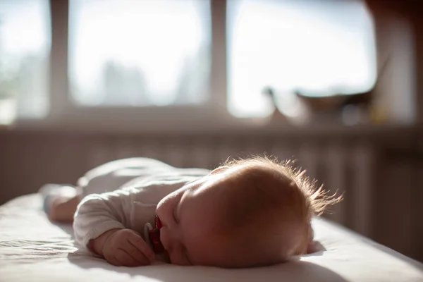 Säugling Liegt Mit Schnuller Licht Der Sonne Auf Dem Bett — Stockfoto