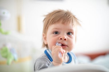 Bebek yatakta ısırıyor.