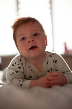 Yatakta yatan bebek oyun oynuyor.