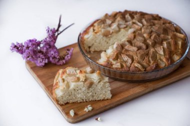 Kek tarçın yukarıdan bir menekşe çiçek ile bir ahşap tahta üzerinde beyaz bir arka plan üzerinde Kazıklı..