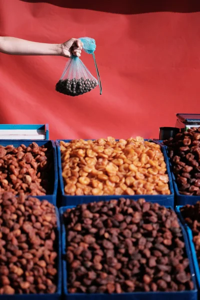 Ruka na trhu suché plody na pozadí červený stan — Stock fotografie