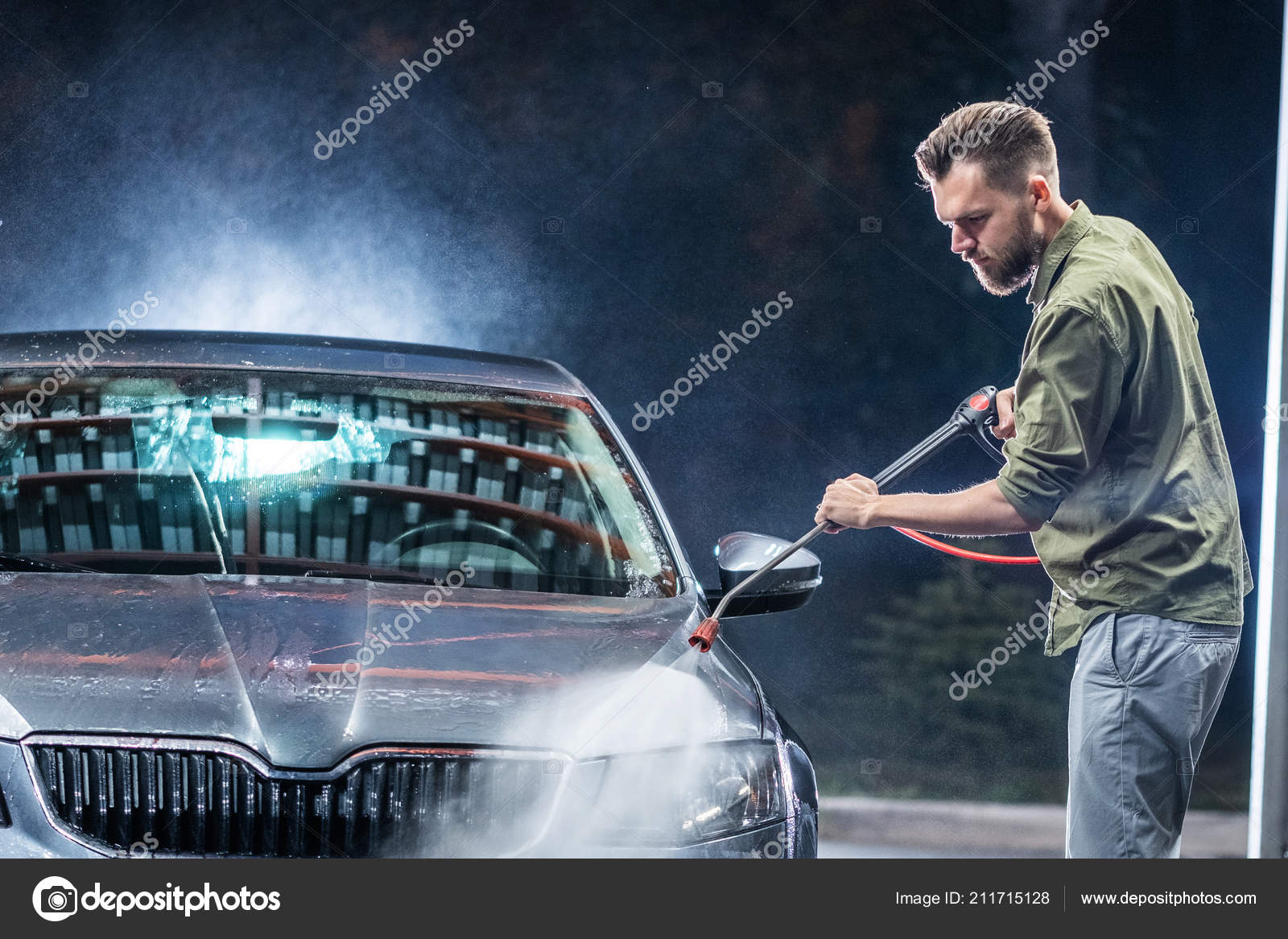ひげや車洗浄機で男は 夜ショップ洗浄に高圧洗浄機で灰色の車を洗う ストック写真 C Vasilkamalov