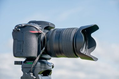 Bir tripodun üstüne iliştirilmiş lensli kamera