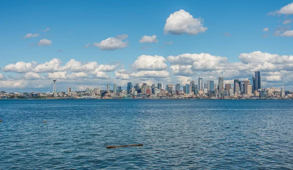 A view of the Seattle skyline with puffy clouds above.