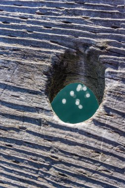 Ahşap iskele korkuluk aşağıdan yansıyan ışık ile bir delik bir closeup çekim.