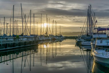 Des Moines, Washington'da Des Moines Marina'da demirli tekne arkasında güneş batıyor.
