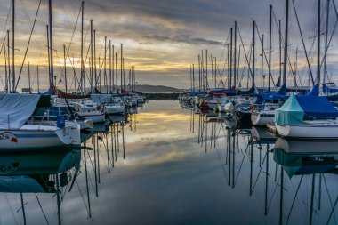 Des Moines, Washington'da Des Moines Marina'da demirli tekne arkasında güneş batıyor.