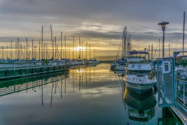 Des Moines, Washington'da Des Moines Marina'da demirli tekne arkasında güneş batıyor.