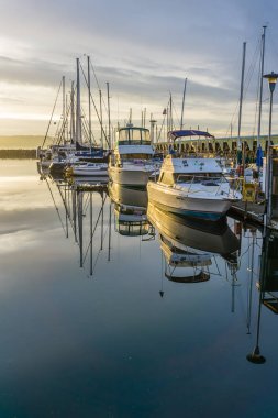 Des Moines, Washington'da Des Moines Marina'da demirli tekne arkasında güneş batıyor.