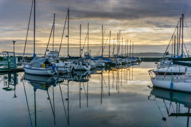 Des Moines, Washington'da Des Moines Marina'da demirli tekne arkasında güneş batıyor.