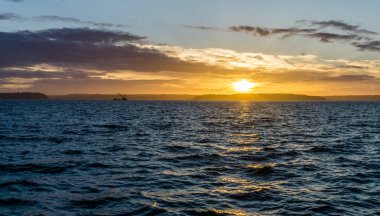 Bir vinç gemi ve golden sunset West Seattle, Washington Puget ses genelinde bir görünüm.
