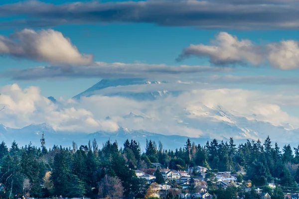 Puffy clouds cover Mount Rainier in Washington State.