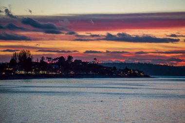 Gökyüzü güneş Batı Seattle, Washington'da Alki plajda olarak renkleri ile zengin.