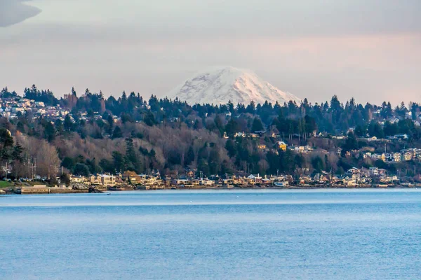 The top of Mount Rainier can be seen above the West Seattle shoreline.