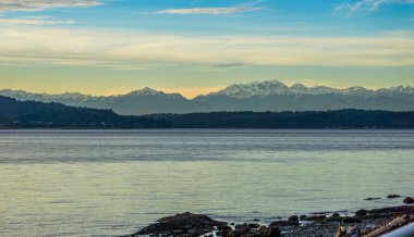 Gün batımında Puget Sound arasında Olimpiyat dağ görünümü.