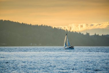 Bir yelkenli Puget Sound ile mesafe tepelerde arasında hareket eder.