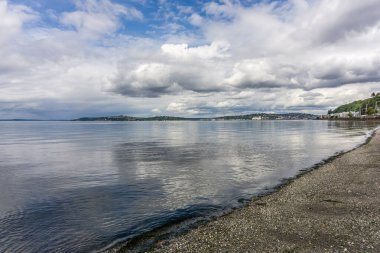 Bulutlar Alki Sahili üzerinde uçuyor Batı Seattle, Washington 'da.