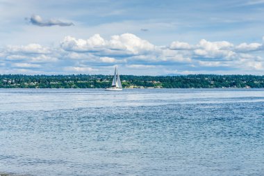 Puget Sound 'da bir yelkenli üstünde dalgalanan bulutlarla.