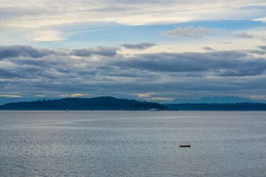 Bulutlar ağaçların ve Kuzeybatı Pasifik 'teki Puget Sound' un üzerinde asılı..