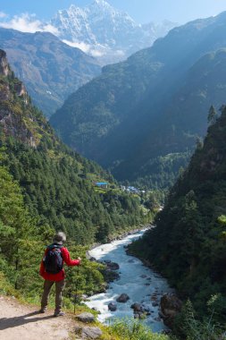 Trekking adam güzel dağ ve sırt çantası ve trekking kutup ile şelale önünde ayakta güzel sahne.