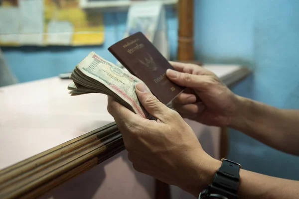 タイ人男性の手はネパール カトマンズにおける交換金店で Changemoney 後ネパールお金とタイのパスポートを保持します — ストック写真
