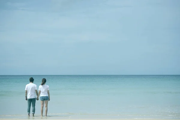 Back view of asian couple holding hand standing in sea on honeymoon period,mood and tone with valentine concept.