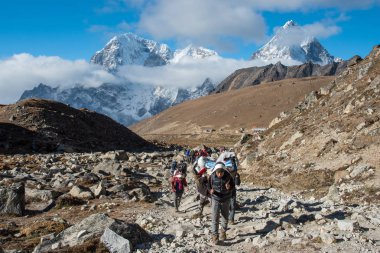 Trekker ve porter ile dağ ve nehir Lobuche everest ana kampı bölgesinde, Nepal Dingboche üzerinden giderken manzara