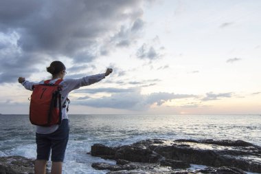 Bayan deniz kıyısında bulutlu günde tarafından bir çanta kadar beyaz gömlek elinde