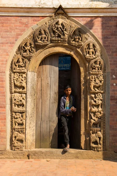 Katmandu, Nepal-Ekim 16,2018: Katmandu, Nepal Patan Duba meydanında kapıdan çıkıp tanımlanamayan Nepal çocuk 