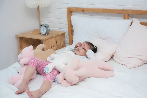 Asya bebek kız yatakta bebek mutsuz ile uyanma.