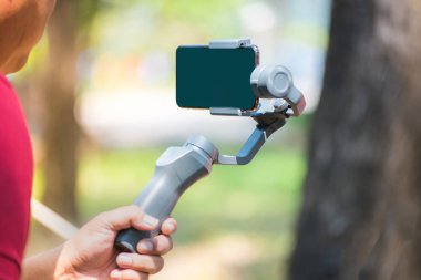  Dji Osmo Mobil 2 Steadicam. Samsung telefon. Cep telefonu için sabitleyici, akıllı telefon. Onun Youtube kanalı için üstten şehir vuruyor bir genç çocuk.