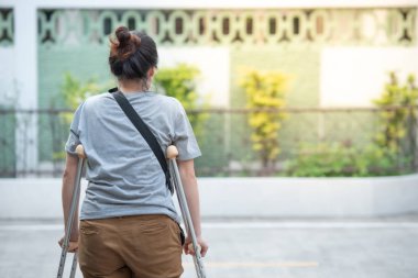 Koltuk değneği veya baston veya diz desteği st ile engelli kadın