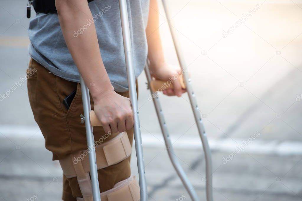Disabled woman with crutches or walking stick or knee support st