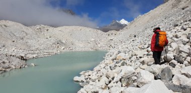 Nepal Everest ana kamp güzergahı Gokyo gölü yakınlarında zemin üzerinde buzul malt üzerinde sırt çantası ile adam yürümek.