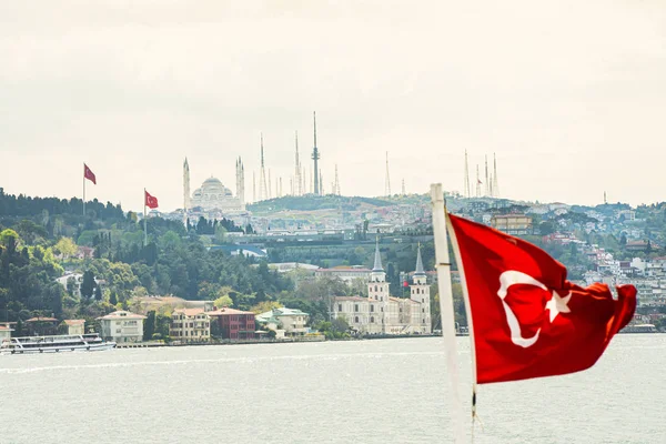 Cityscape v Istanbulu se starými mešit a starým městem s tureckou vlajkou a lodí vpředu. — Stock fotografie