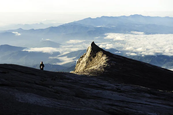 Trekker stoi na górze Kinabalu z południowym szczytu i góry — Zdjęcie stockowe