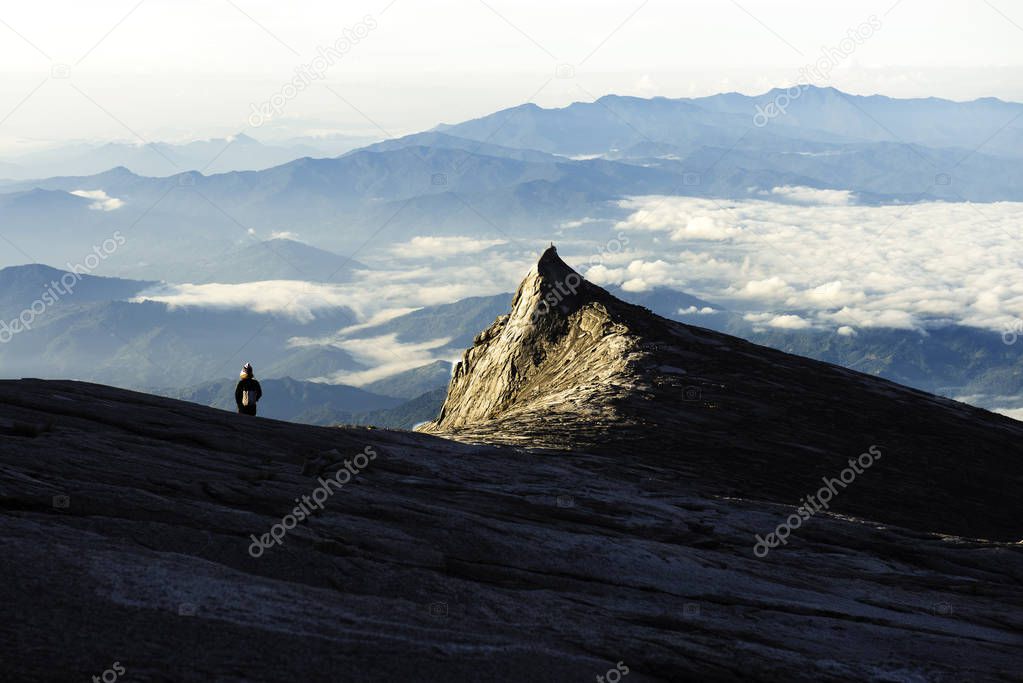 Trekker standing on Kinabalu mountain with south peak  and mountain