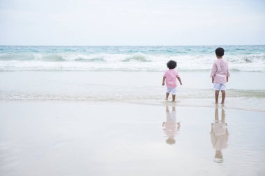 Yaz tatillerinde sahilde oynayan iki çocuk. Nat'teki çocuklar