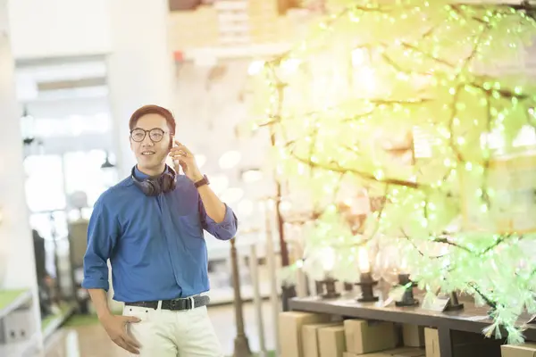 Asiático joven hombre de negocios vestido en casual usando smartphone y cop — Foto de Stock