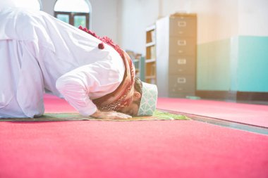 Genç Müslüman Arap adam camide diz ve baş dokunmatik zemin üzerinde oturup