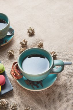 siyah plaka üzerinde bazı taze renkli macaroon ile sarkma arka plan sıcak ot siyah çay fincan, çay saati kavramı.