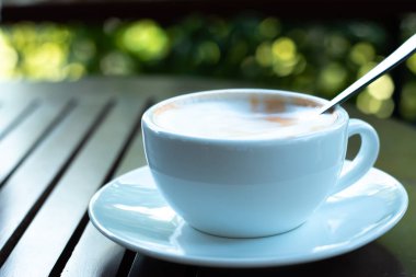 Ahşap masada taze kahve molası fincan.