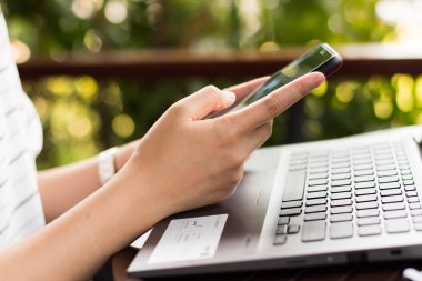 Women using a mobile phone in cafe on bokeh background.