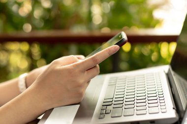 Women using a mobile phone in cafe on bokeh background.