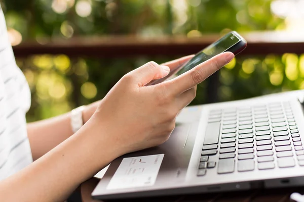Women using a mobile phone in cafe on bokeh background.