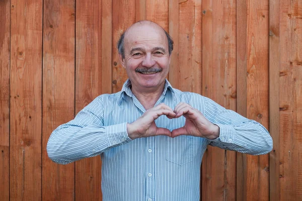 Человек, создающий каркас сердца для рук — стоковое фото