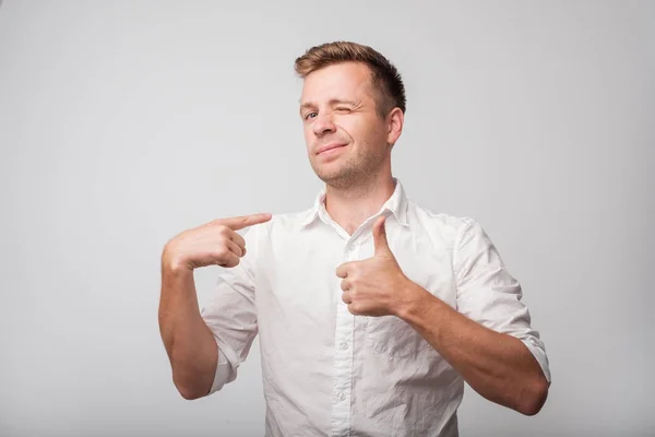 Homem de negócios feliz em camisa branca segurando polegares para cima . — Fotografia de Stock