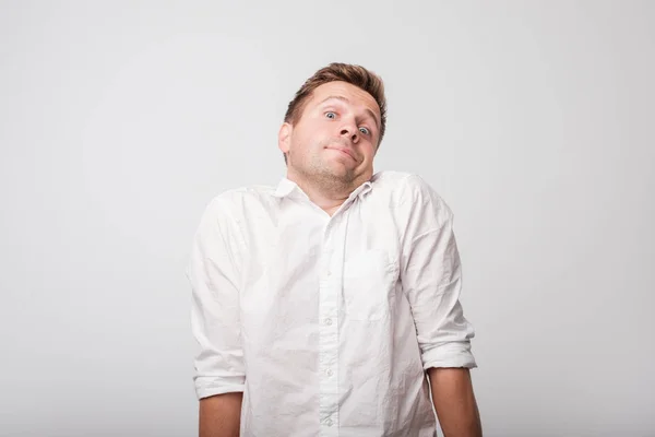 Retrato de chico caucásico guapo siendo sorprendido y despistado, siendo inseguro y no seguro sobre la respuesta — Foto de Stock