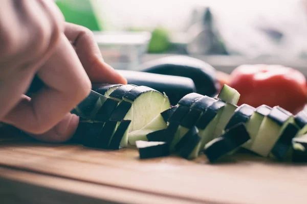 Auberginenscheiben mit Messer waagerecht auf einem Brett schneiden — Stockfoto